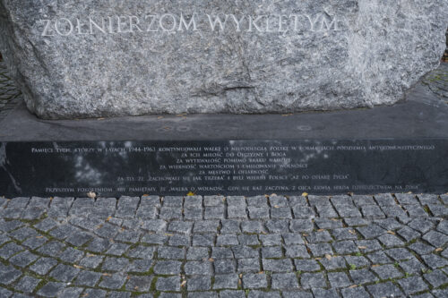 Zdjęcie ukazuje zbliżenie na plakietę umieszczoną na pomniku z napisem dotyczącym pamięci o żołnierzach wyklętych.